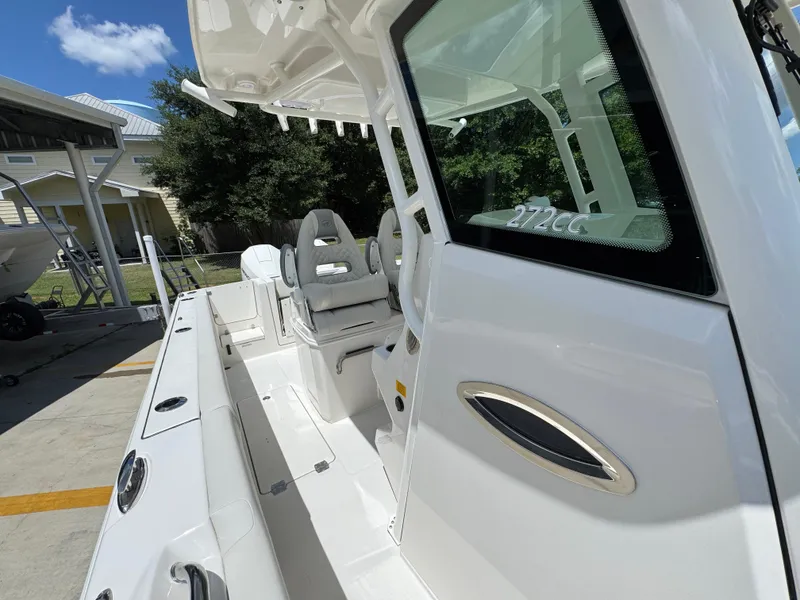 Slide: The Image of 2026 Sailfish 272 CC boat interior with seating and console, docked outdoors. - 29