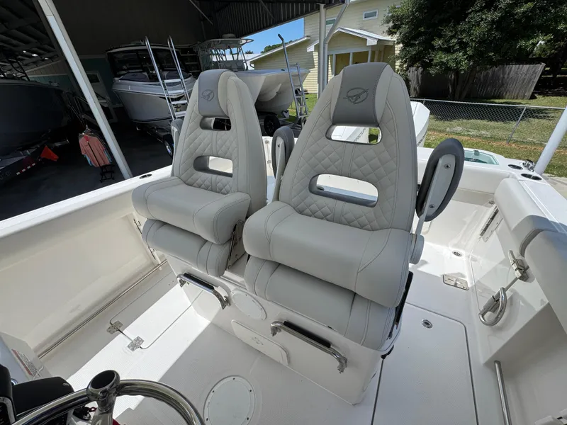 Slide: The Image of 2026 Sailfish 272 CC boat interior with two cushioned seats in a covered storage area. - 31