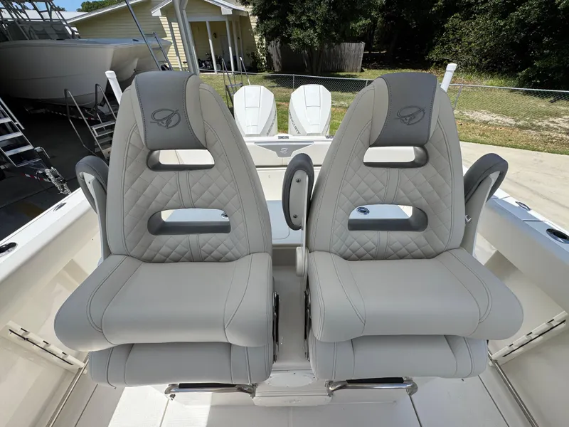 Slide: The Image of 2026 Sailfish 272 CC boat seats with quilted design and armrests, parked outdoors. - 32