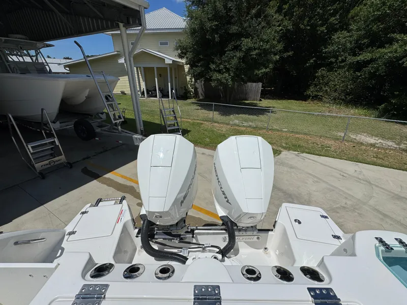 Slide: The Image of 2026 Sailfish 272 CC boat with dual Mercury outboard engines in a sunny yard. - 43
