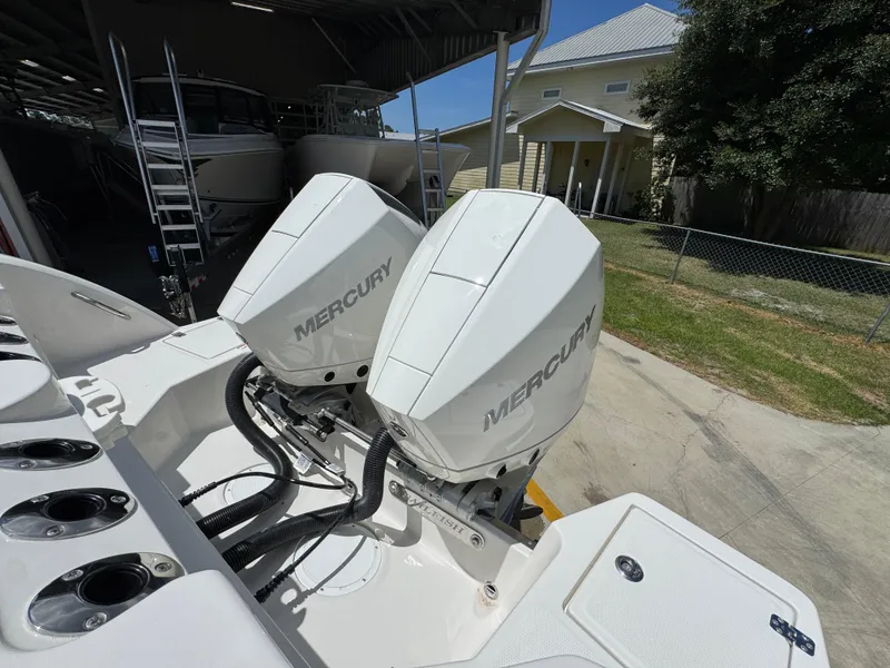 Slide: The Image of Twin Mercury outboard engines on a 2026 Sailfish 272 CC boat, parked outdoors. - 44