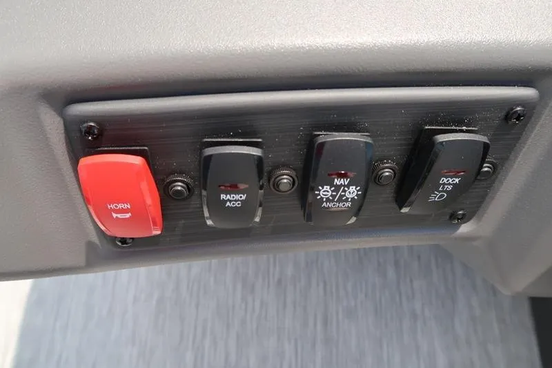 Slide: The Image of Control panel of 2026 Bennington S Quad Bench 22 SSR with horn, radio, navigation switches. - 24