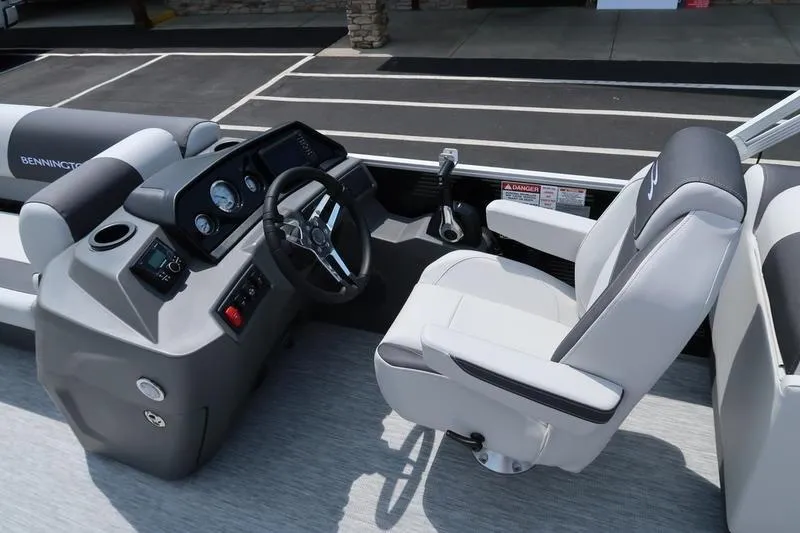 Slide: The Image of 2026 Bennington S Quad Bench 22 SSR boat interior with steering console and seating. - 25