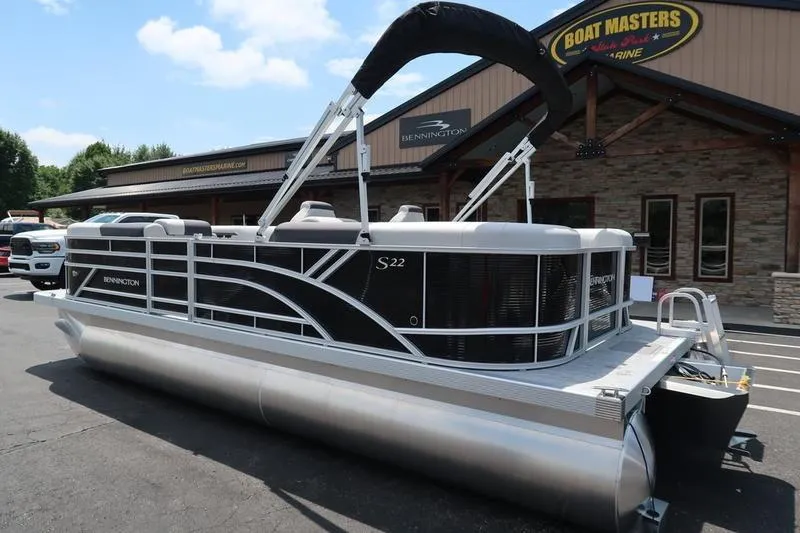 Slide: The Image of 2026 Bennington S Quad Bench 22 SSR pontoon boat parked outside dealership. - 6