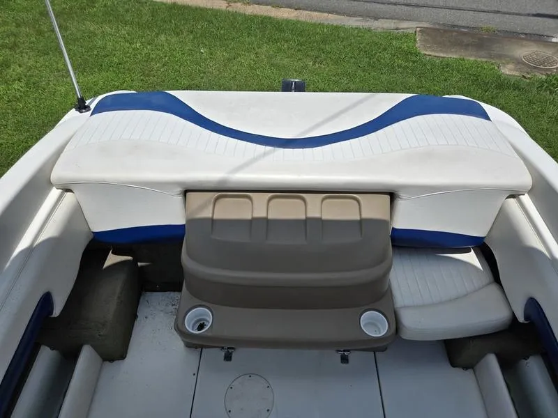 Slide: The Image of 2004 Glastron SX 195 boat interior with white and blue seating, cup holders, and storage. - 11