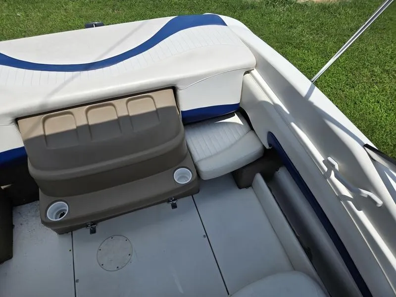 Slide: The Image of 2004 Glastron SX 195 boat interior with seating and cup holders, on grassy background. - 12