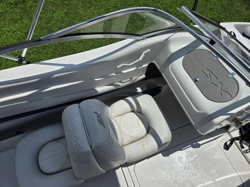 Slide: The Image of 2004 Glastron SX 195 boat interior with white seating and dashboard, viewed from above. - 14