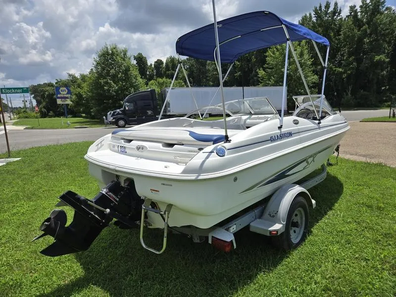Slide: The Image of 2004 Glastron SX 195 boat on trailer with blue canopy, parked on grass. - 7
