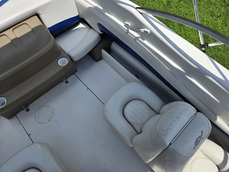 Slide: The Image of 2004 Glastron SX 195 boat interior with white seating and cup holders. - 9