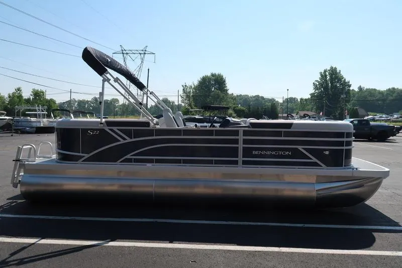 Slide: The Image of 2026 Bennington S Quad Bench 22 SSR pontoon boat parked outside dealership. - 3