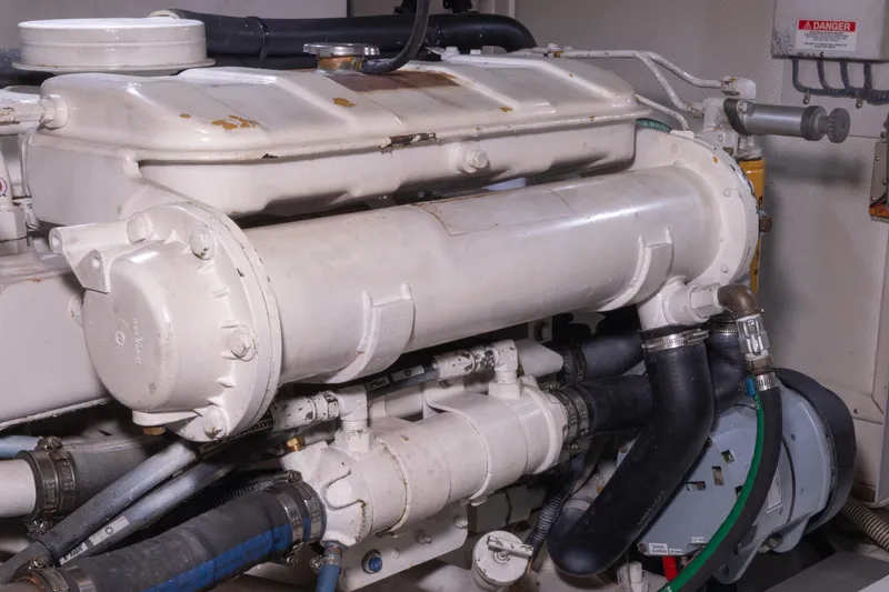 Slide: The Image of Engine room of 2002 Grand Banks 46 Europa yacht, showcasing mechanical components and piping. - 12