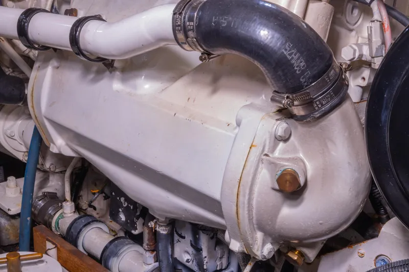 Slide: The Image of Engine compartment of a 2002 Grand Banks 46 Europa yacht, featuring pipes and hoses. - 13