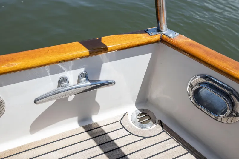 Slide: The Image of Deck detail of 2002 Grand Banks 46 Europa yacht with wooden rail and metal cleat. - 23