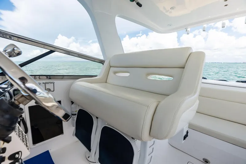 Slide: The Image of 2018 Intrepid 430 Sport Yacht interior with white seating and ocean view. - 29