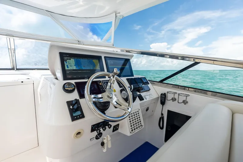 Slide: The Image of Cockpit of 2018 Intrepid 430 Sport Yacht with navigation screens and steering wheel, ocean view. - 30