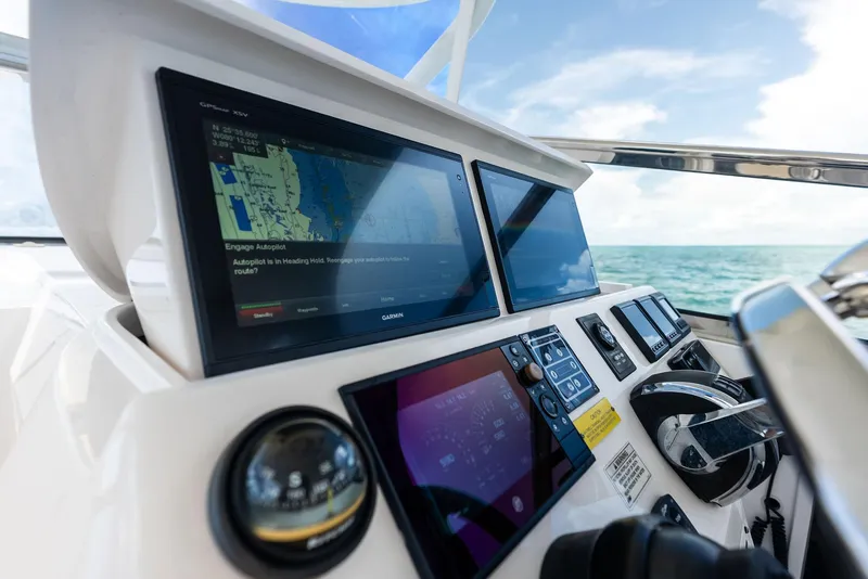 Slide: The Image of 2018 Intrepid 430 Sport Yacht dashboard with navigation screens and controls, ocean view. - 32