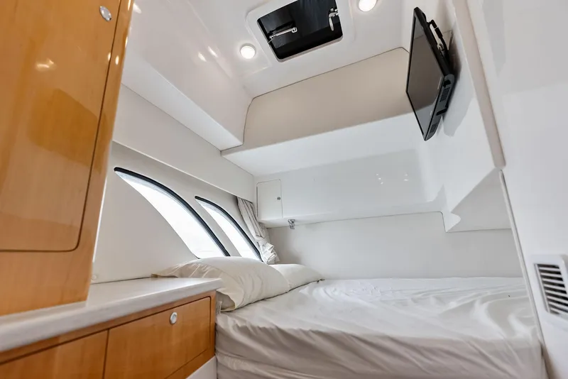 Slide: The Image of 2018 Intrepid 430 Sport Yacht cabin interior with bed, TV, and porthole windows. - 45