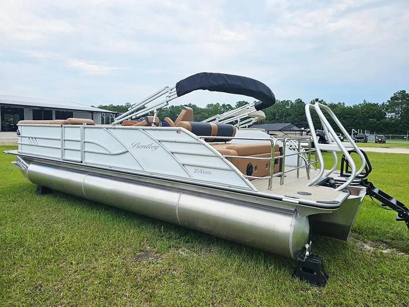 Slide: The Image of 2026 Bentley Pontoons Elite 253 Swingback Dual Captain Full Tritoon on grass, side view. - 4