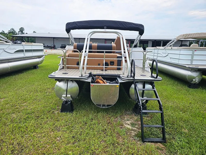 Slide: The Image of 2026 Bentley Pontoons Elite 253 Swingback Tritoon, rear view on grass, showcasing ladder and seating. - 5