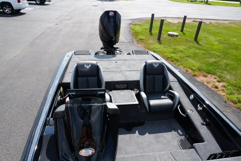Slide: The Image of 2026 Phoenix 721 ZXL boat interior with dual seats and motor, parked on pavement. - 17