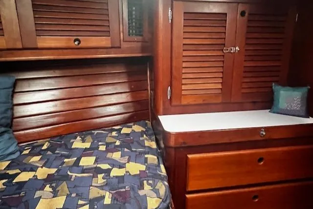 Slide: The Image of Cozy cabin interior of 1990 Bristol 47.7 Cutter/Sloop with wooden furnishings and patterned bedding. - 12