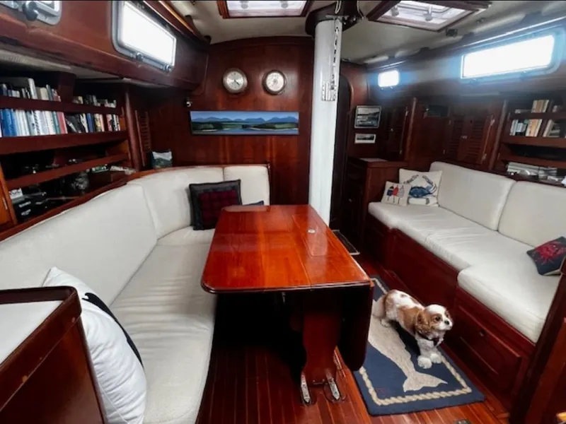 Slide: The Image of Cozy interior of a 1990 Bristol 47.7 Cutter/Sloop with wooden table and dog. - 2