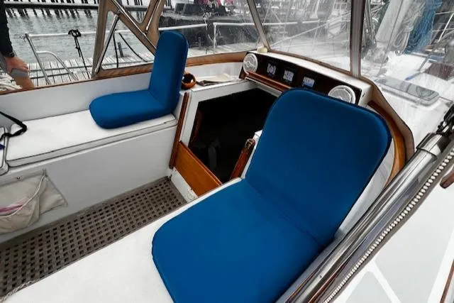 Slide: The Image of Cockpit of 1990 Bristol 47.7 Cutter/Sloop with blue cushioned seating and navigation instruments. - 24