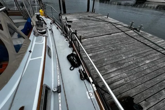 Slide: The Image of Bristol 47.7 Cutter/Sloop, 1990, docked beside wooden pier, overcast day. - 32