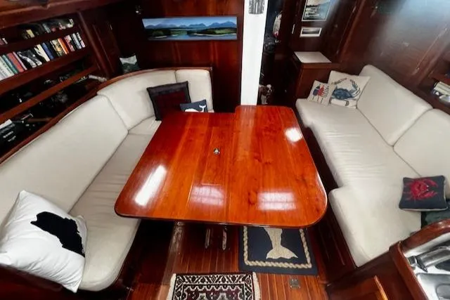 Slide: The Image of Interior of 1990 Bristol 47.7 Cutter/Sloop with wooden table and cushioned seating. - 4