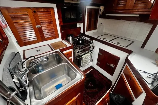 Slide: The Image of Interior of 1990 Bristol 47.7 Cutter/Sloop yacht kitchen with wooden cabinetry and stainless steel sink. - 7