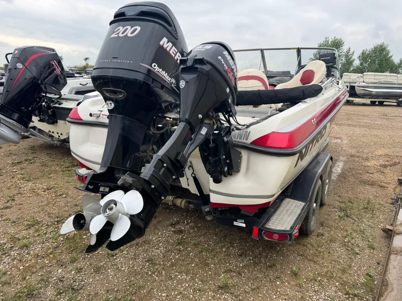 Slide: The Image of 2011 Nitro 290 Sport boat in a garage, featuring red and white design with Mercury engines. - 3