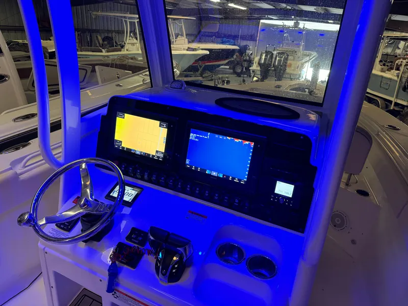 Slide: The Image of 2021 Sea Hunt Gamefish 27 boat dashboard with dual navigation screens and illuminated controls. - 9