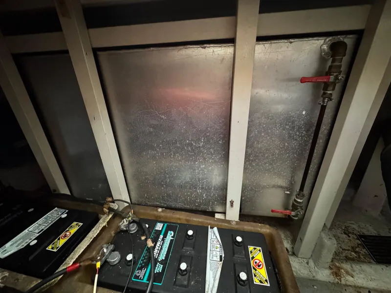 Slide: The Image of Battery compartment of 1983 Rough Water Flybridge boat with metal panel and valves. - 15