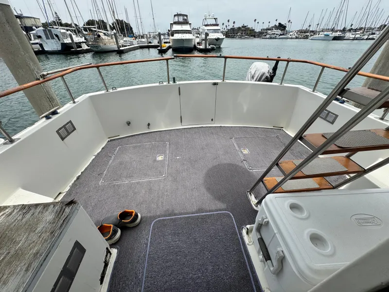 Slide: The Image of 1983 Rough Water Flybridge boat deck with stairs, docked in marina with other boats. - 5