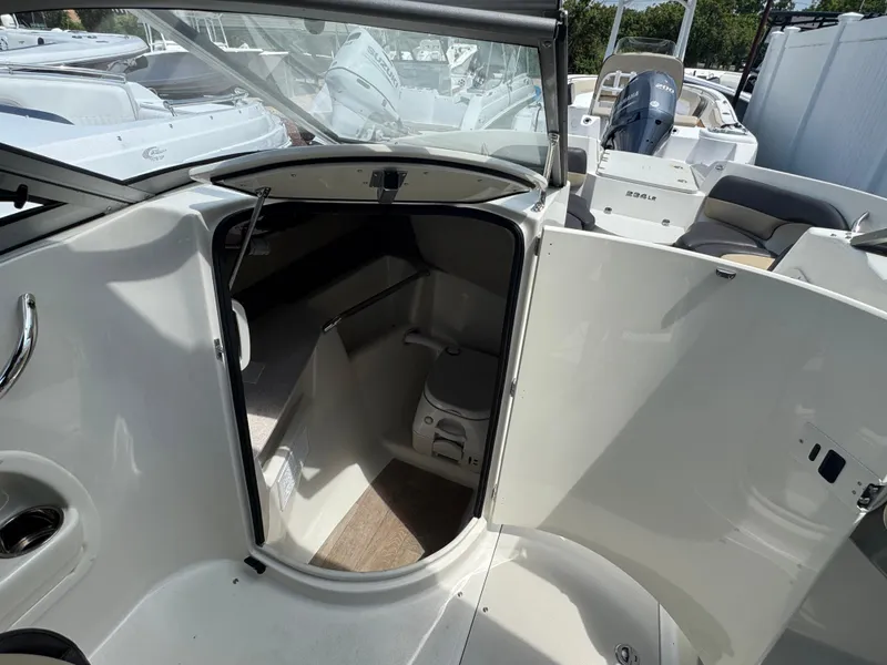 Slide: The Image of 2018 Stingray 234 LR boat interior with open cabin door and visible seating area. - 13