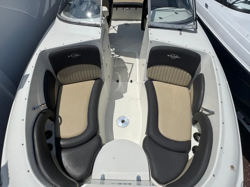 Slide: The Image of 2018 Stingray 234 LR boat interior with beige and black seating. - 19