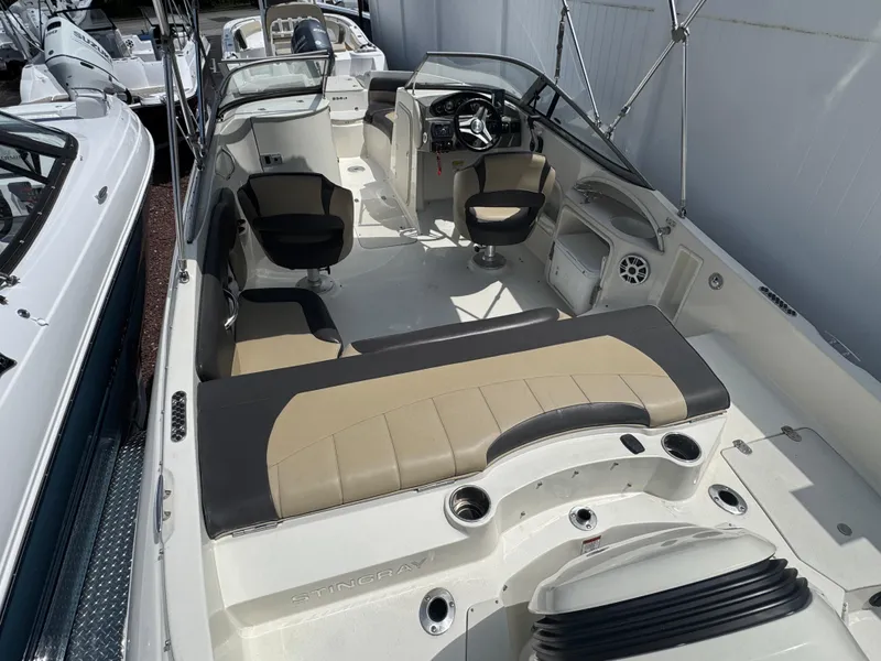 Slide: The Image of 2018 Stingray 234 LR boat interior with seating, steering wheel, and storage compartments. - 2