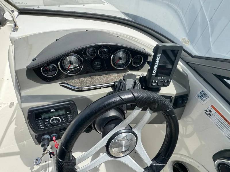 Slide: The Image of 2018 Stingray 234 LR boat dashboard with steering wheel, gauges, and Lowrance navigation system. - 8