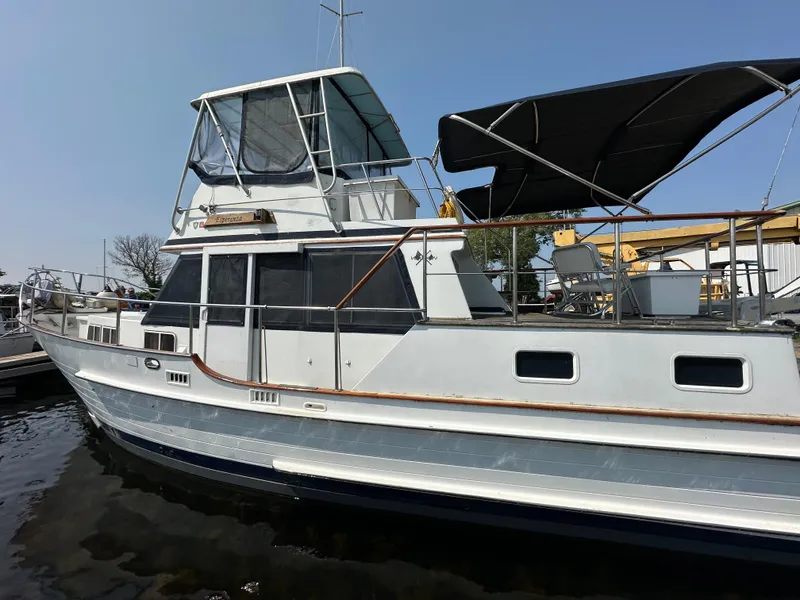 Slide: The Image of 1996 Island Gypsy 36 Aft Cabin yacht docked, featuring spacious deck and canopy. - 2