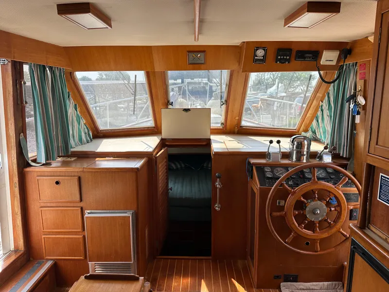 Slide: The Image of 1996 Island Gypsy 36 Aft Cabin interior with wooden helm, steering wheel, and nautical instruments. - 23