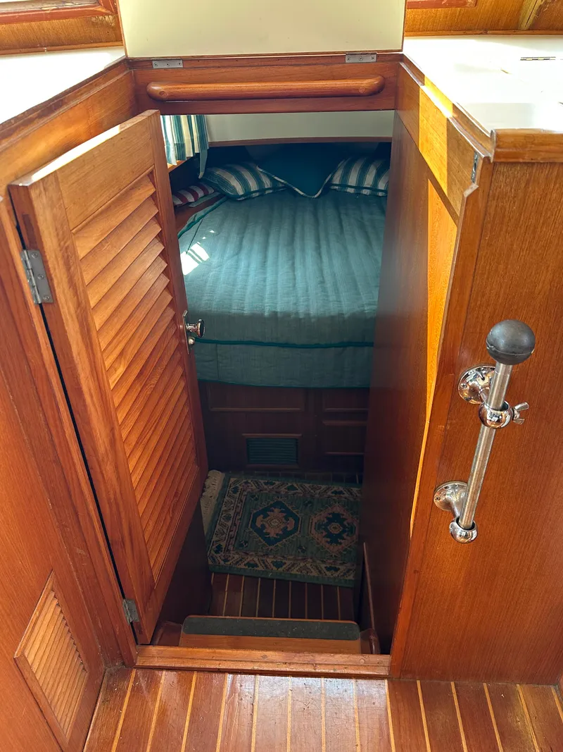 Slide: The Image of 1996 Island Gypsy 36 Aft Cabin interior with wooden door and cozy bed. - 27