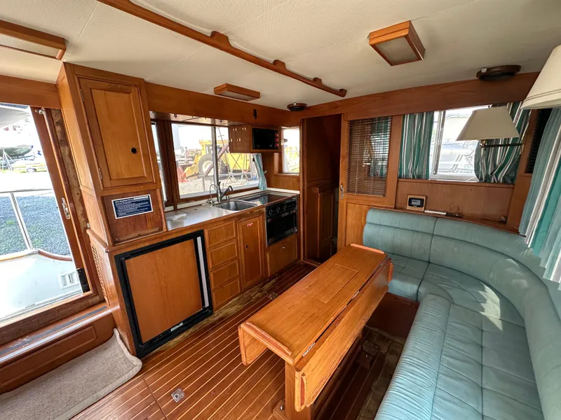 Slide: The Image of Interior of 1996 Island Gypsy 36 Aft Cabin with wood finish and teal seating. - 29