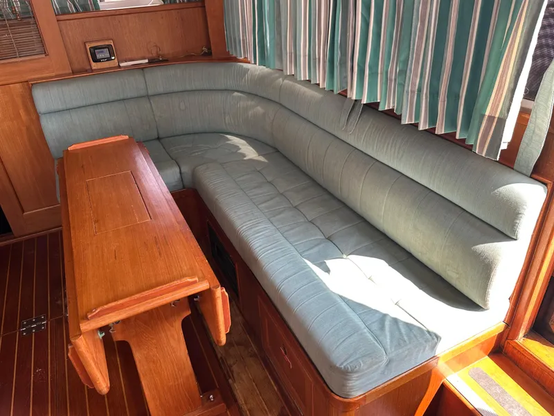 Slide: The Image of 1996 Island Gypsy 36 Aft Cabin interior with blue cushioned seating and wooden table. - 30