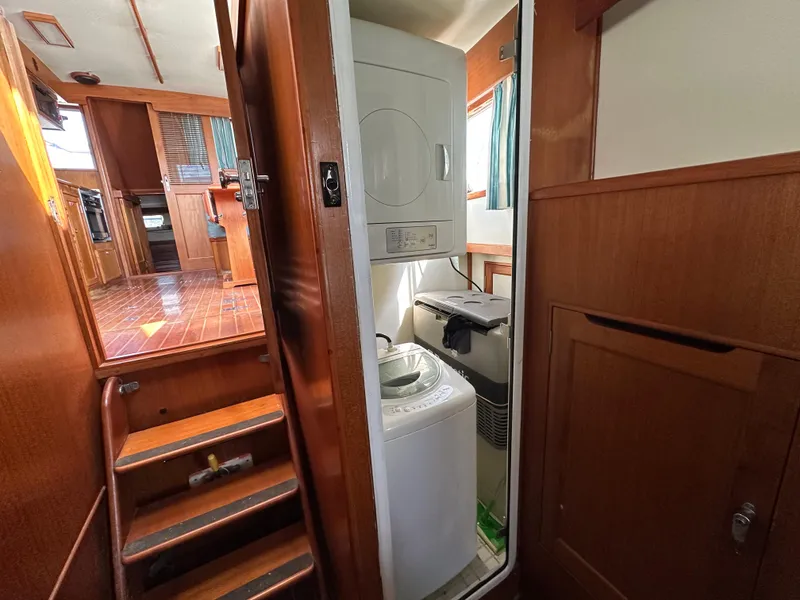 Slide: The Image of 1996 Island Gypsy 36 Aft Cabin interior with laundry area and wooden stairs. - 33