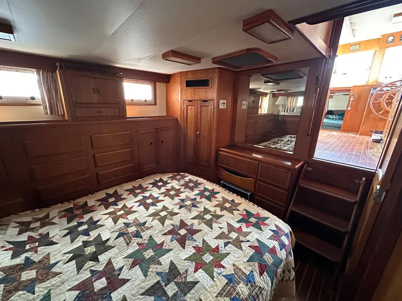 Slide: The Image of 1996 Island Gypsy 36 Aft Cabin interior with quilted bedspread and wooden cabinetry. - 35
