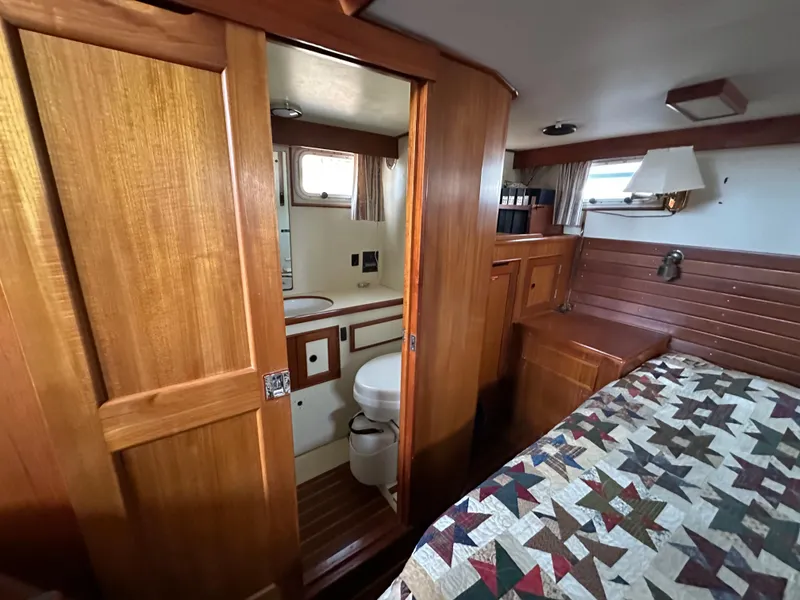 Slide: The Image of 1996 Island Gypsy 36 Aft Cabin interior with wood paneling and quilted bedspread. - 38
