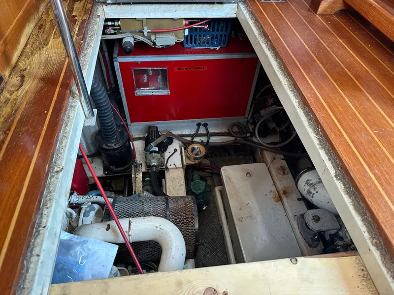 Slide: The Image of Engine room of a 1996 Island Gypsy 36 Aft Cabin with visible machinery and wooden flooring. - 39