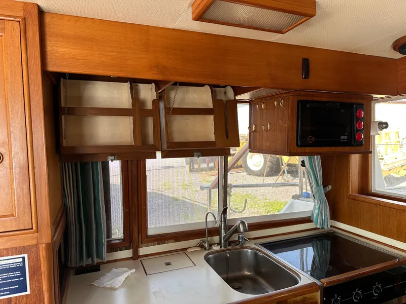 Slide: The Image of 1996 Island Gypsy 36 Aft Cabin kitchen with wood cabinets, sink, and microwave. - 41