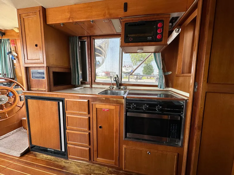 Slide: The Image of 1996 Island Gypsy 36 Aft Cabin kitchen with wood cabinetry, stove, and sink. - 47