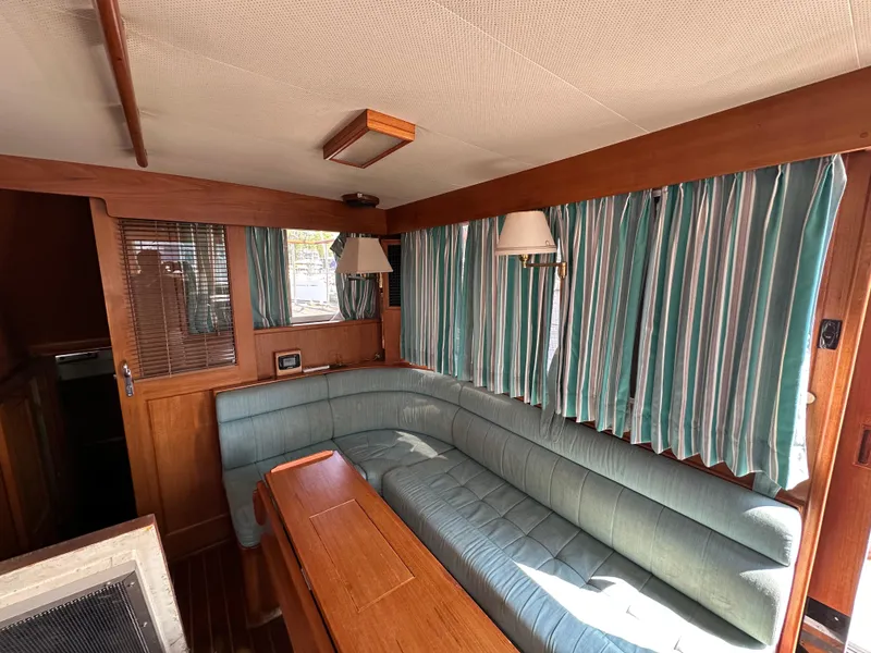 Slide: The Image of Interior of 1996 Island Gypsy 36 Aft Cabin with teal seating and striped curtains. - 49